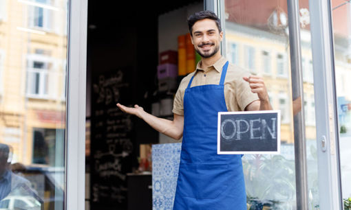 Shop owner holding open sign